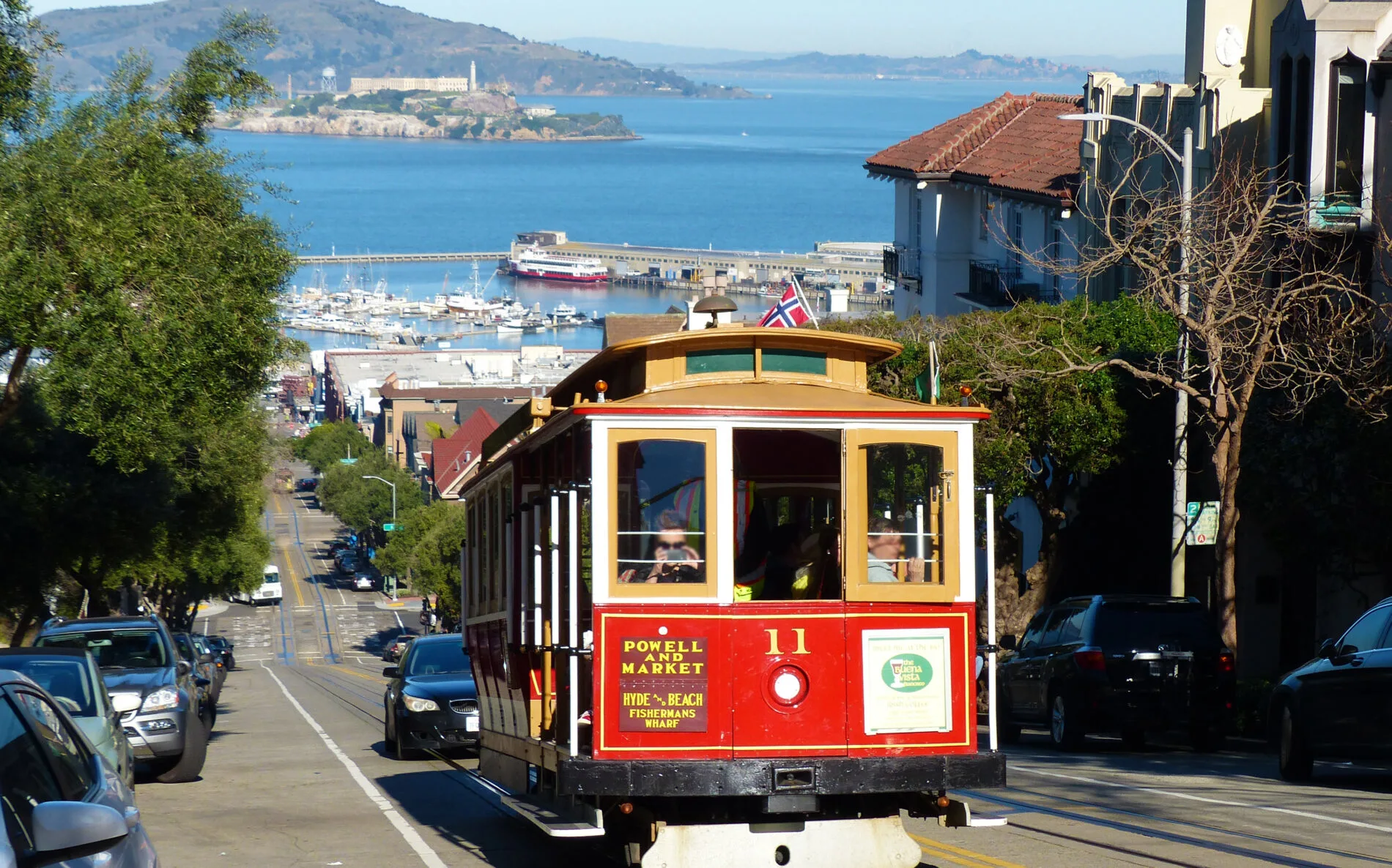 A red Powell-Hyde Line cable car climbs up Russian Hill in San Francisco.