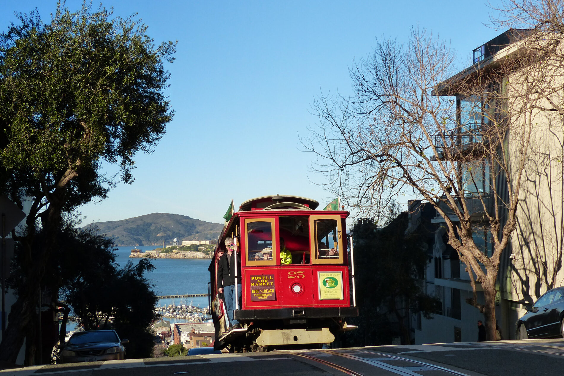 A red cable car climbs to the top of Russian Hill on Hyde Street. It’s a major San Francisco attraction.