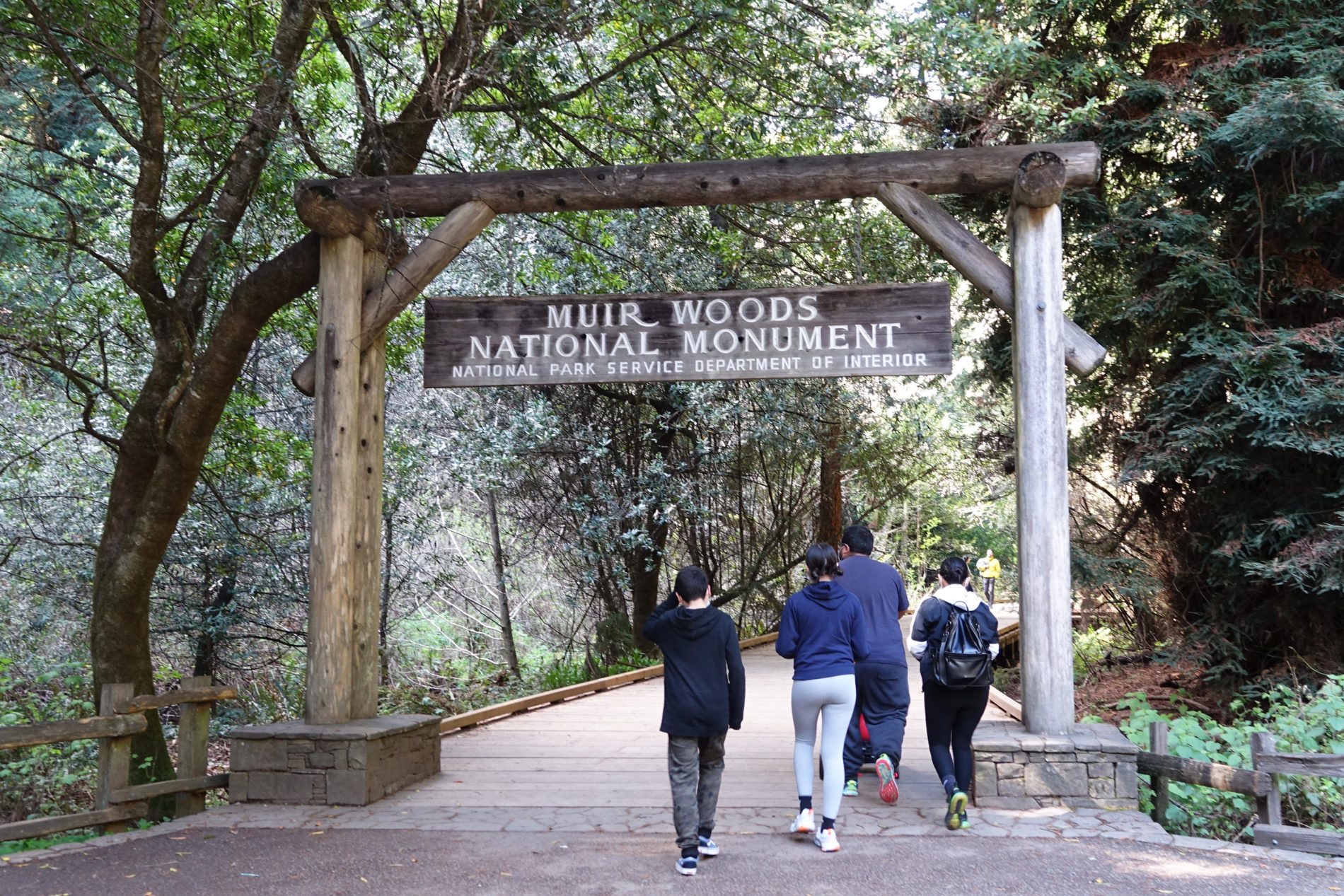 Family walking through the entrance to Muir Woods National Monument.