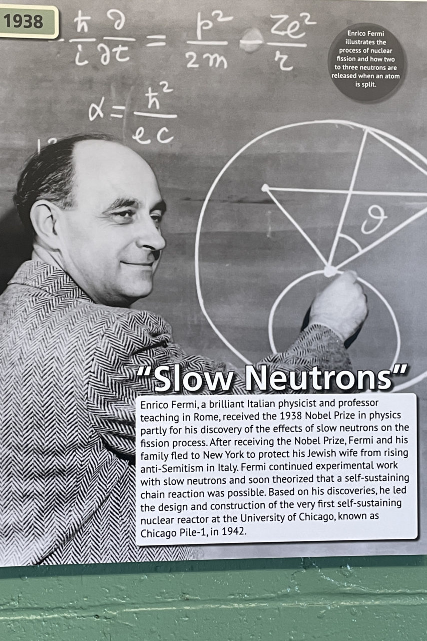 Enrico Fermi at a blackboard illustrating the process of nuclear fission.
