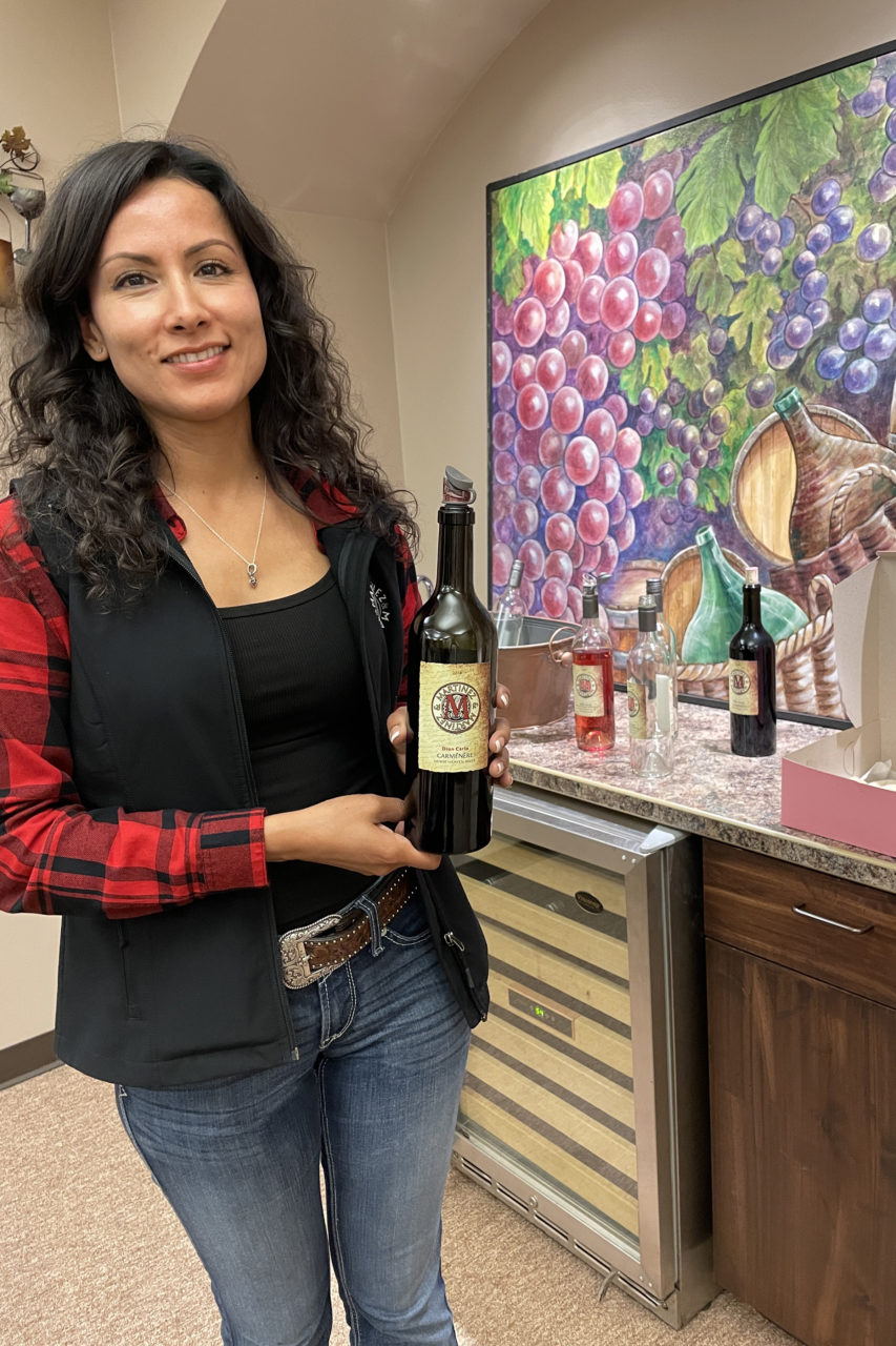 A Martinez and Martinez Winery family member presents a bottle of Carménère.