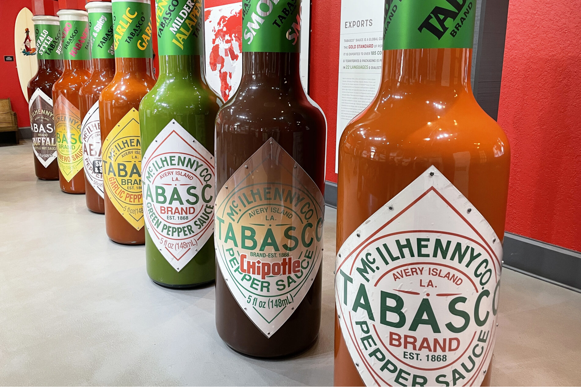 A Tabasco Factory display with a row of seven human-size bottles representing each of the seven Tabasco flavors.