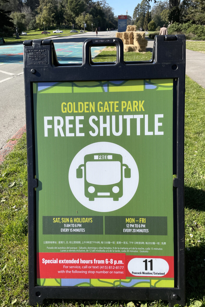 Sign on JFK Promenade with hours and instructions for the free Golden Gate Park shuttle.