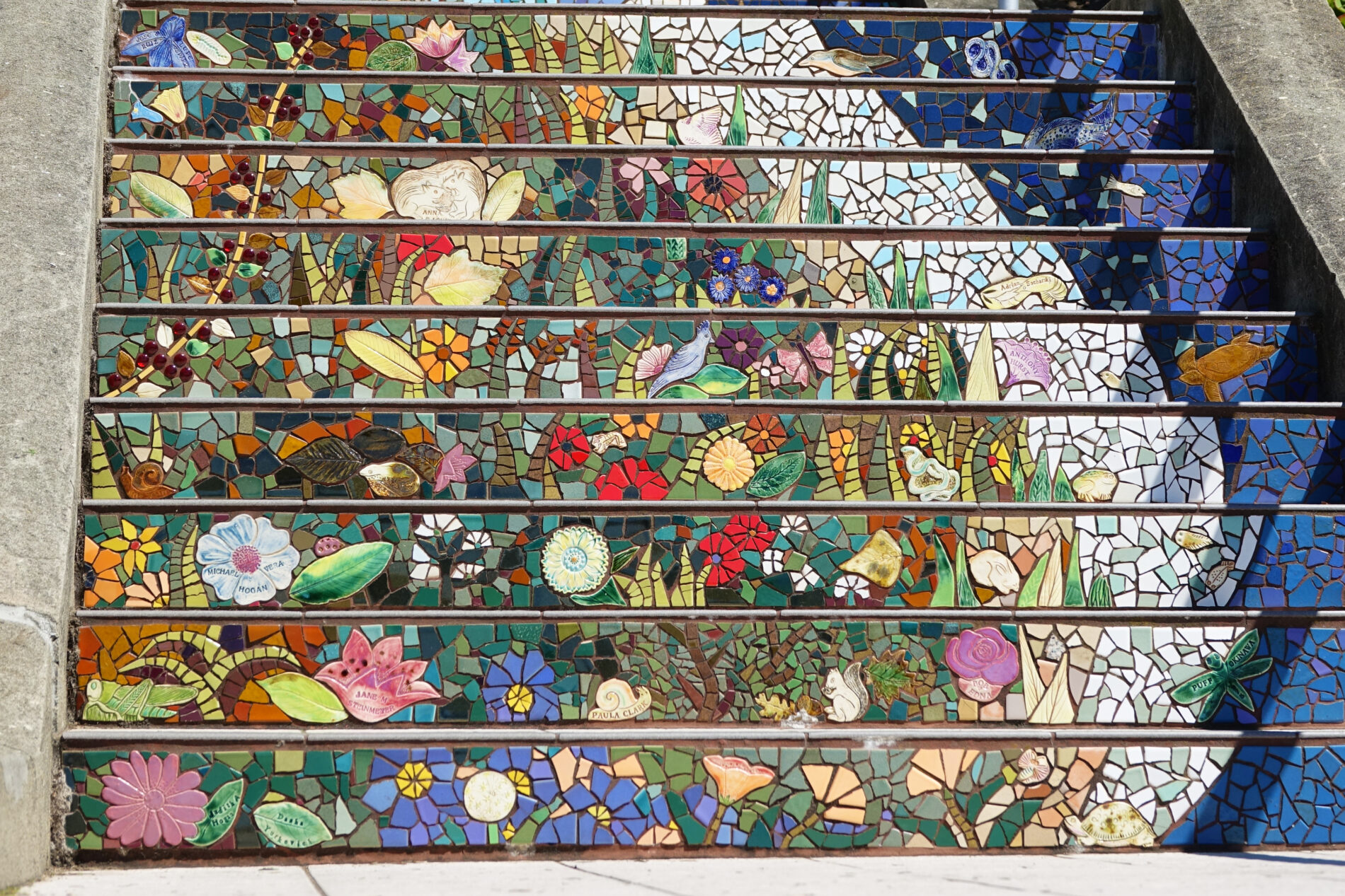 A closeup view of the woodland scene with flowers and small critters in the mosaic tiles on 16th Avenue Steps in San Francisco.